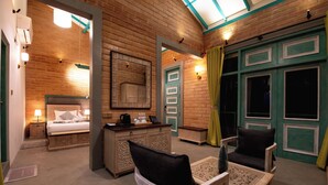 Une pièce confortable avec un lit, un bureau et une chaise, caractérisée par des murs en bois et une porte verte.