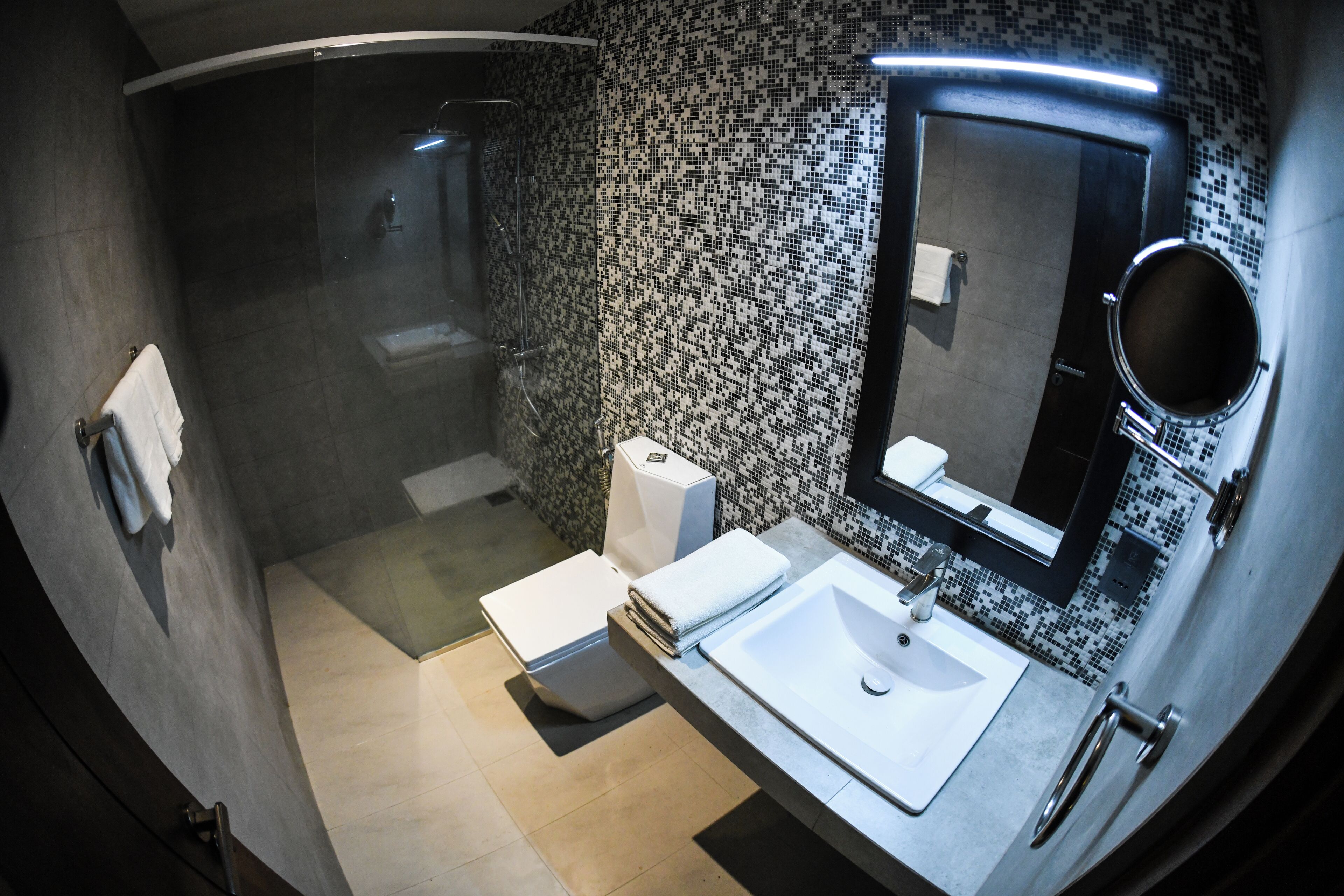 A compact bathroom with a shower, toilet, and sink.