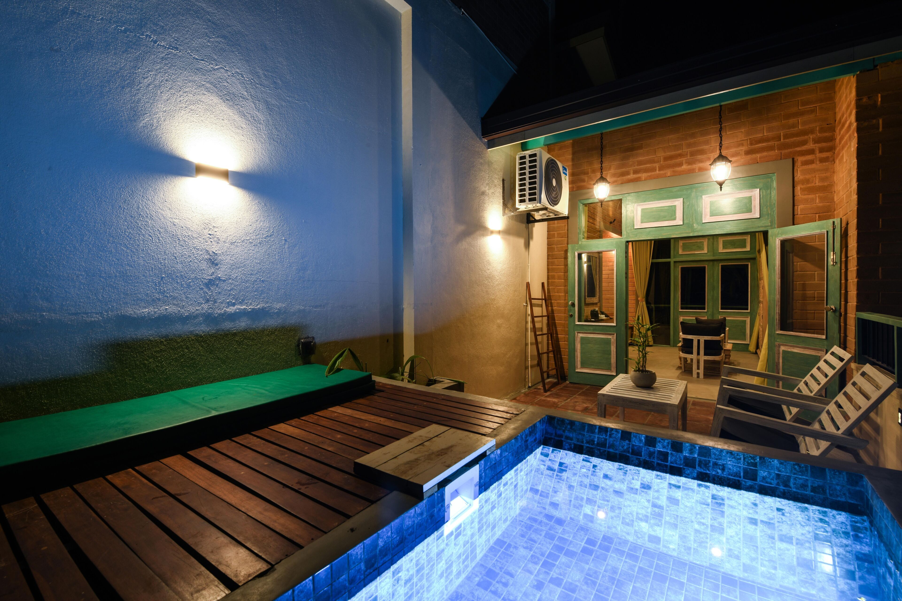 A spa area with a wooden deck, a hot tub, and a seating area with chairs and a table.