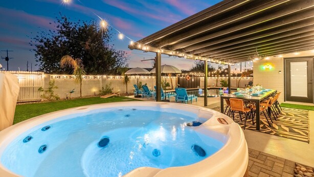 A hot tub with a table and chairs under a covered patio area. - Luxury Gatsby Hideaway - Heated Pool, Hot Tub, Game Room, Fire Pit Near Old Town (Scottsdale)