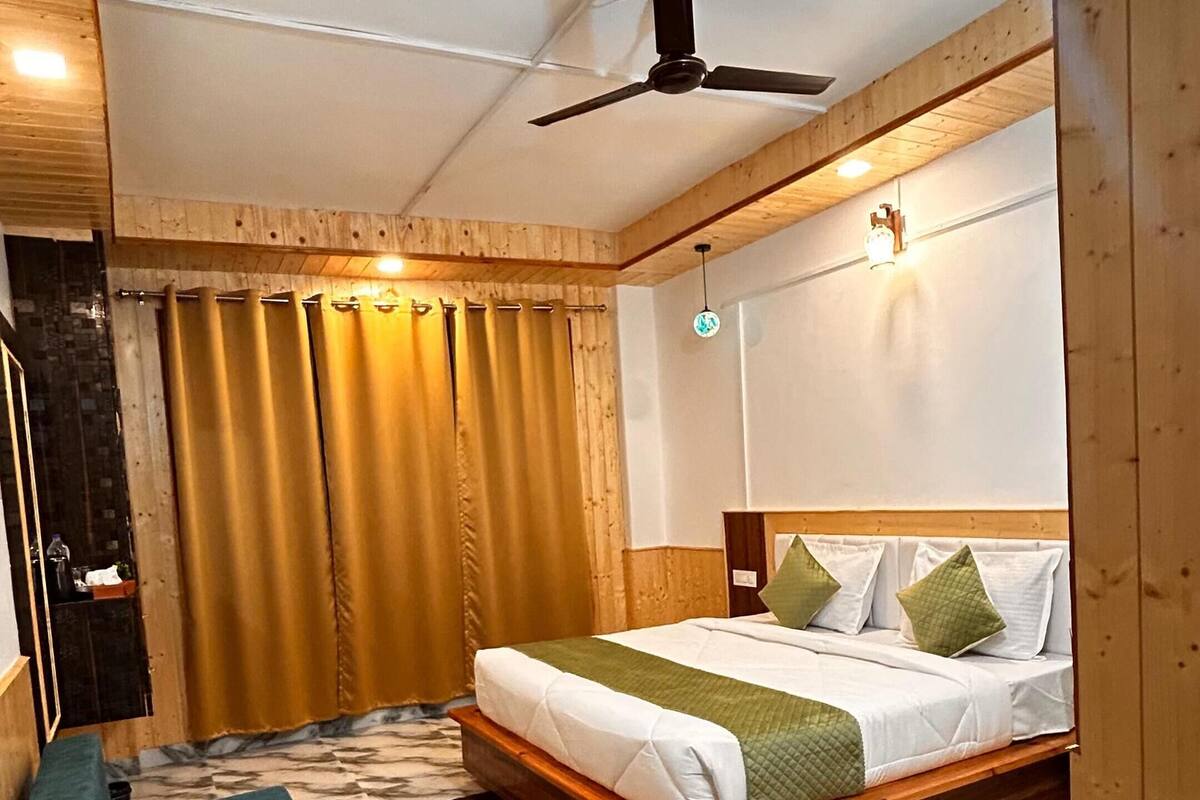 A bedroom with a bed, wooden ceiling, and a marble floor.