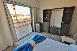 A hotel room with a bed, a desk, a wardrobe, and a view of the outside. - Hostal Hab. 5 Hotelería, Golf, Barra & Playa (San José del Cabo)