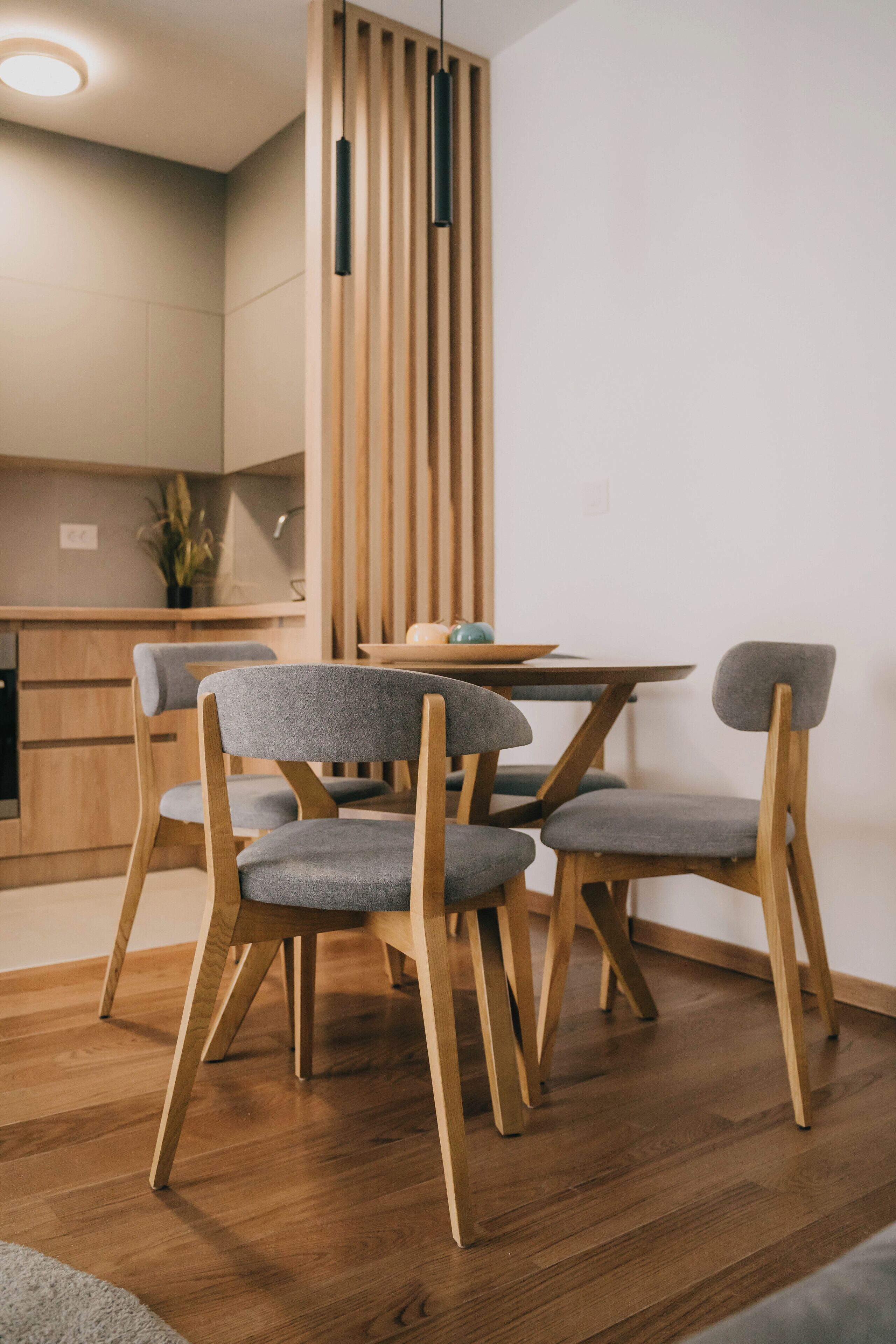 A modern dining area with wooden chairs and a round table.