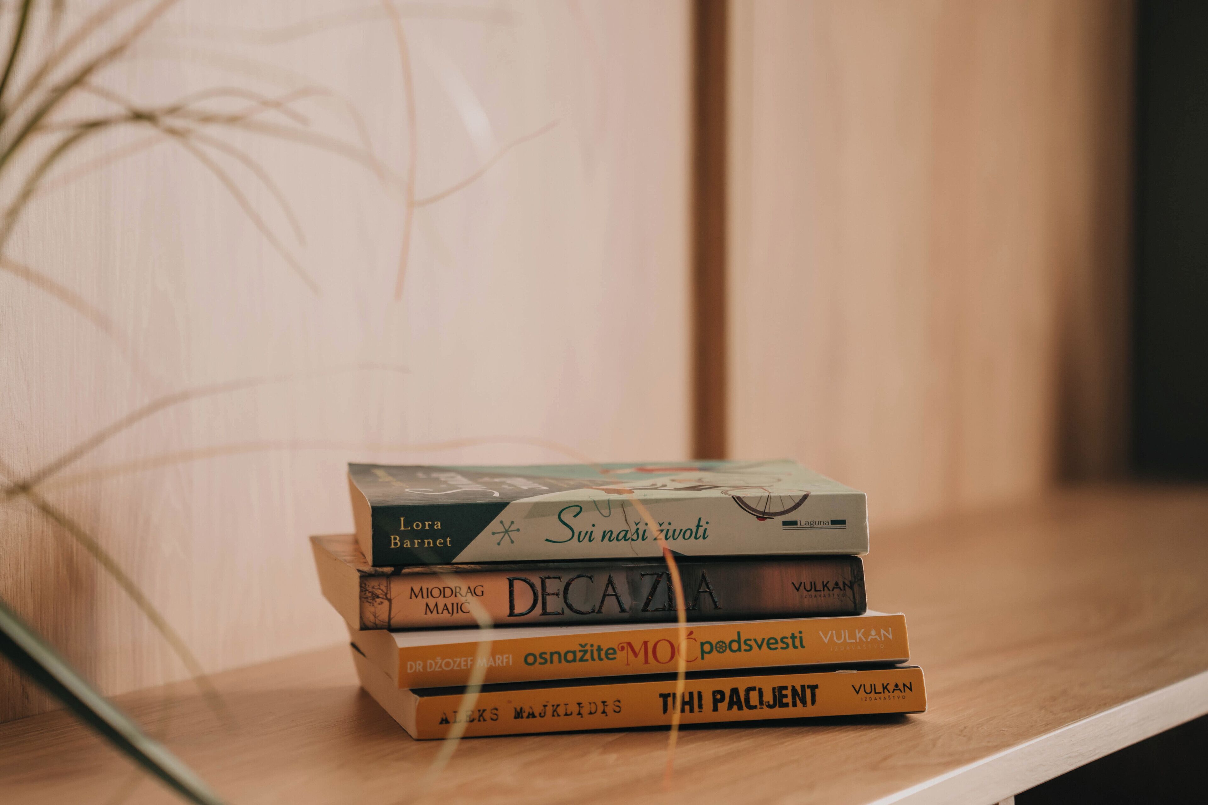 A stack of books on a wooden surface.