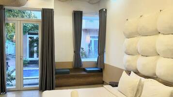 Habitación de hotel con una cama grande, vistas al exterior y un diseño de techo único.