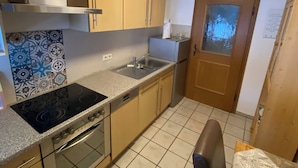 A kitchen with a stove, oven, sink, and cabinets. - Vacation apartment for 2 persons, 50 m², 1 separate bedroom, balcony (Inzell)
