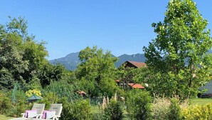 A grassy area with lounge chairs and a mountain backdrop. - Vacation home Harmony 2 to 6 persons (Übersee)