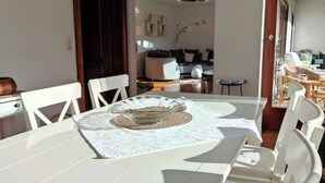 A dining area with a white table, chairs, and a decorative bowl. - Vacation home Harmony 2 to 6 persons (Übersee)