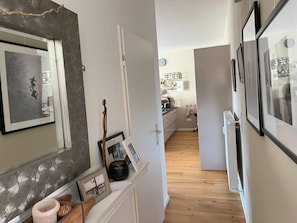 Enter a cozy space with a kitchen area visible in the background, featuring a refrigerator, sink, and kitchen essentials.
