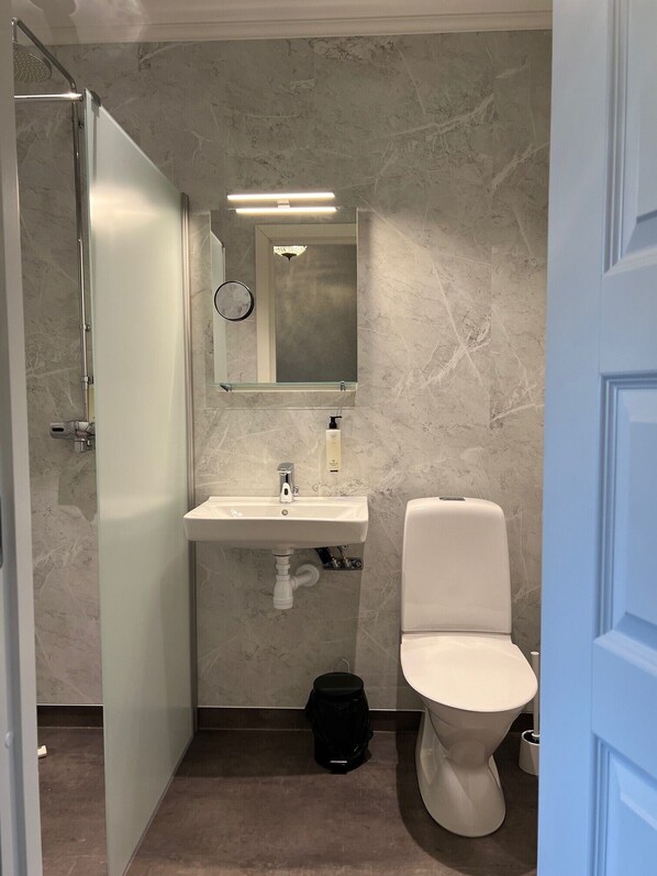 Chuveiro, toalhas de banho, sabonete, shampoo