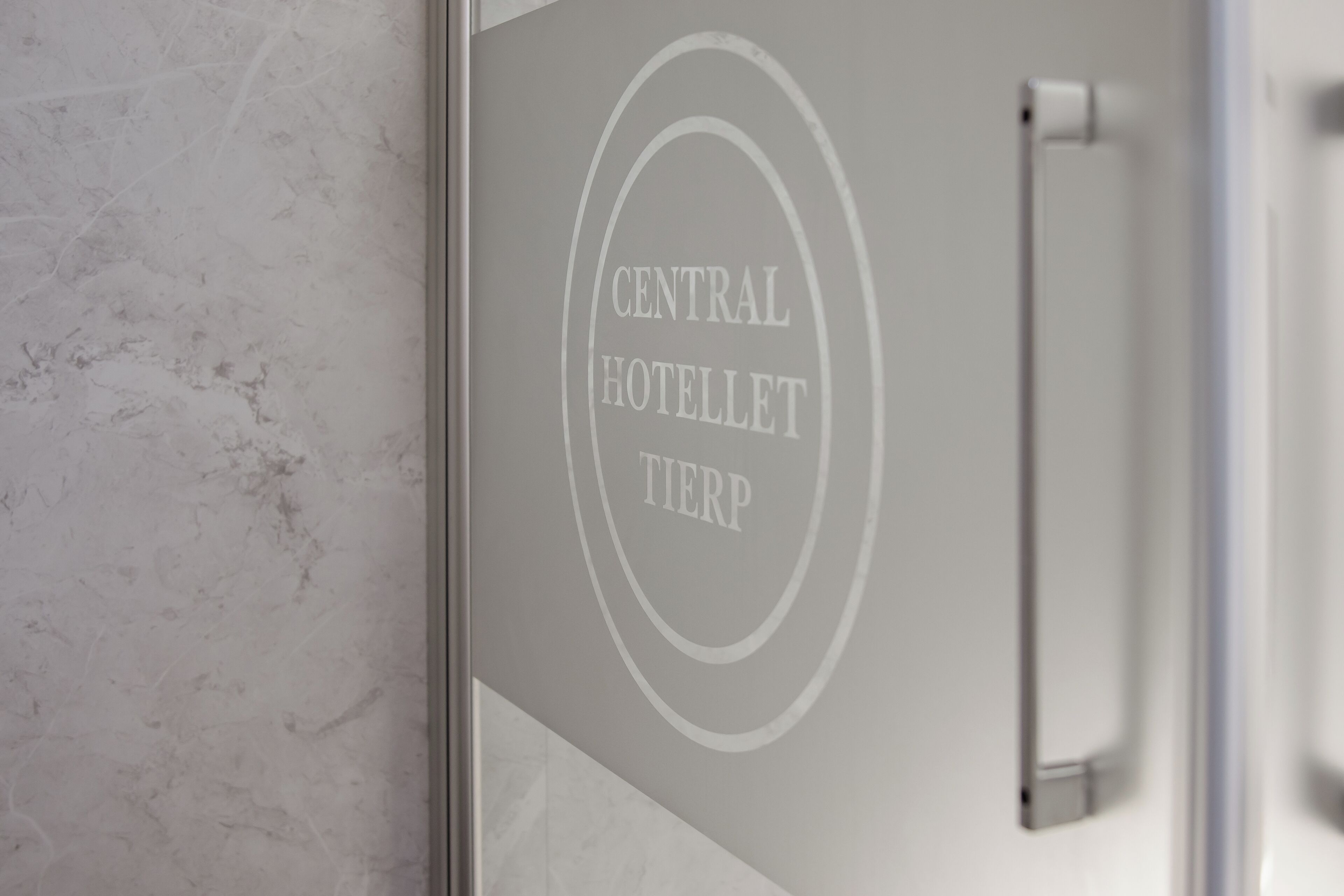 A wall with a logo that reads 'CENTRAL HOTELLET TIERP' and a metallic handle.