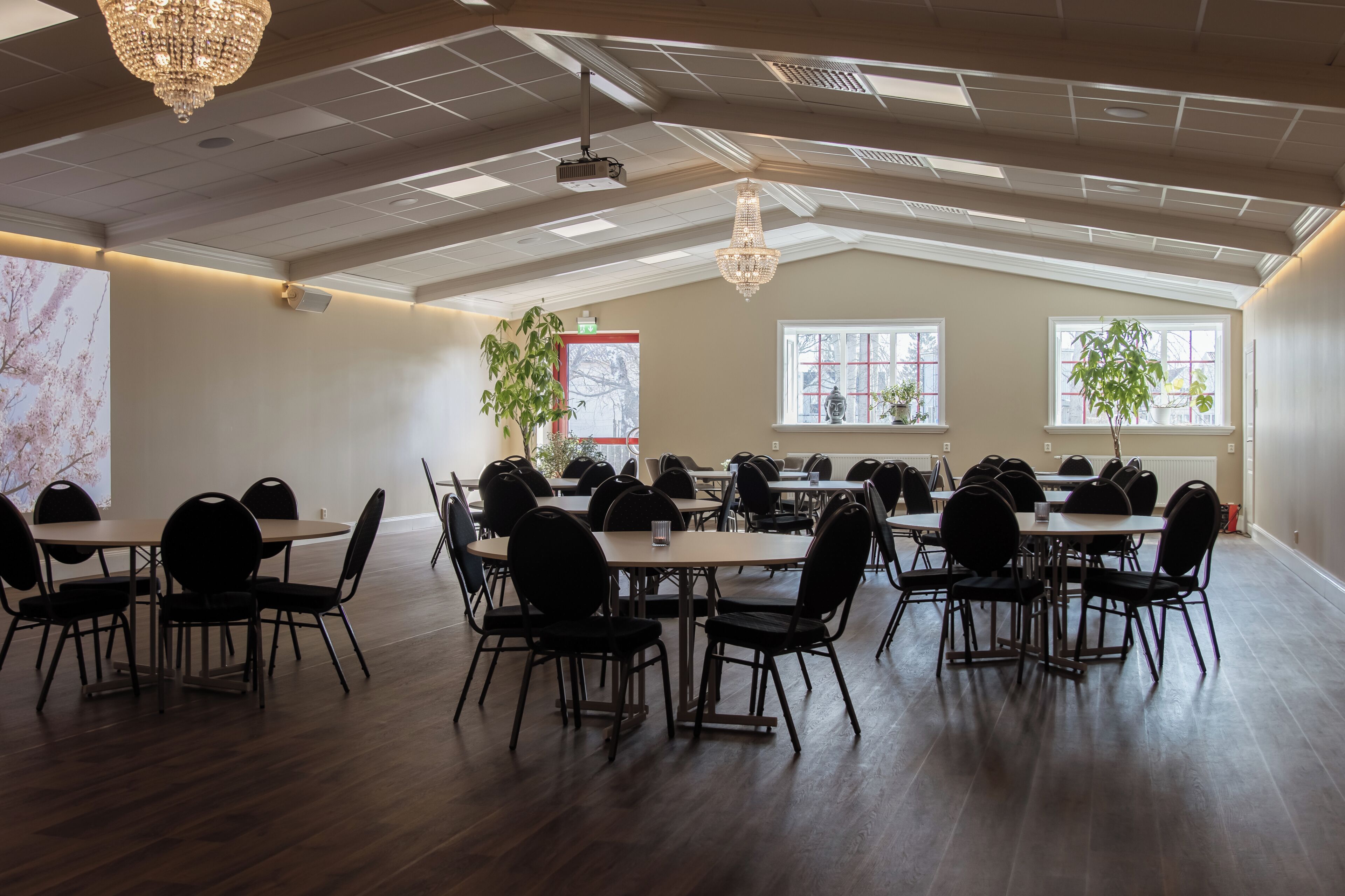 Una amplia sala de conferencias con techos altos, candelabros y ventanas grandes.