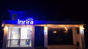 A hotel named 'Inrira' with a signboard, a gated entrance, and a well-lit facade.