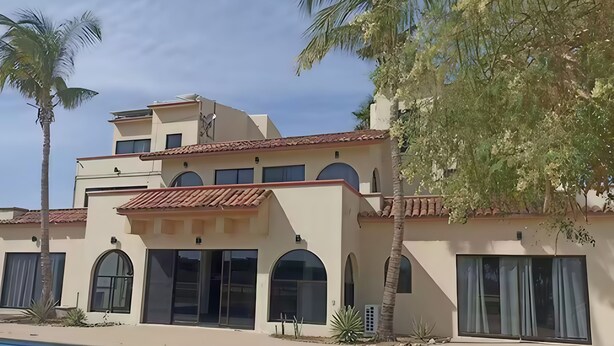 A two-story building with a swimming pool in front.