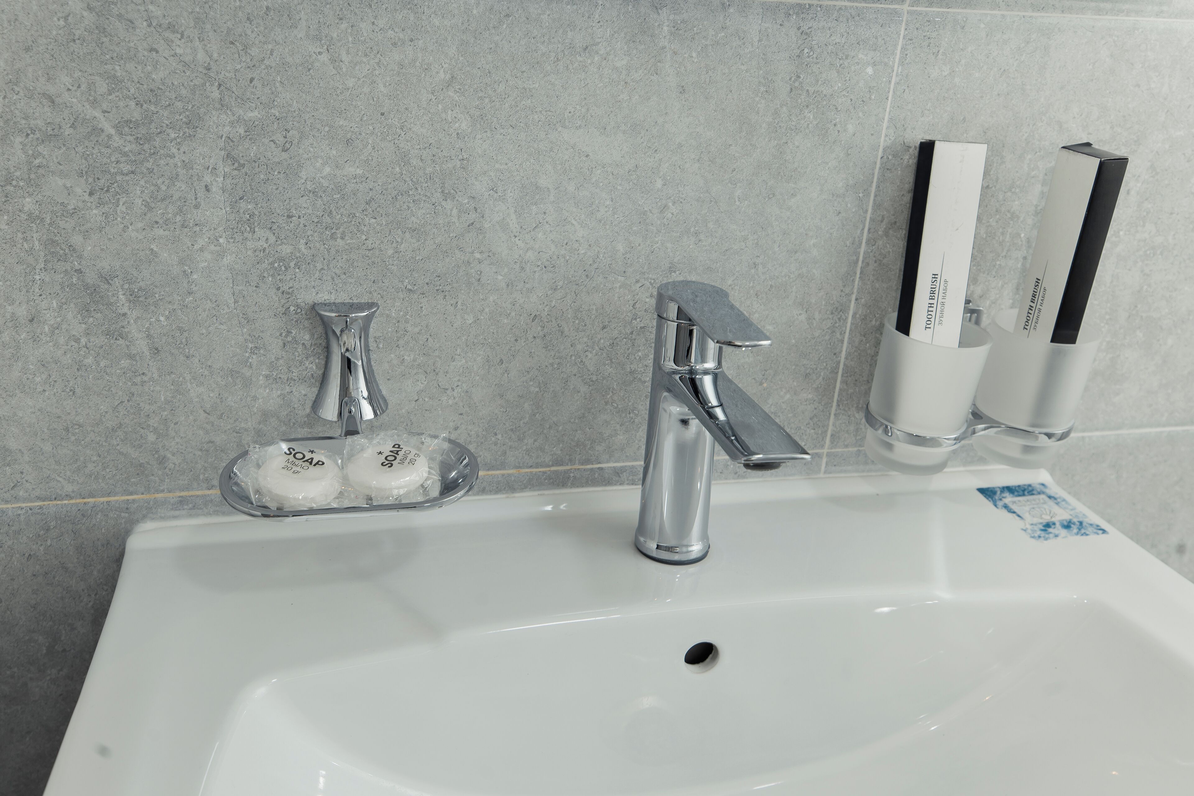Un lavabo de salle de bain avec deux distributeurs de savon et un robinet.
