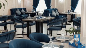 A restaurant with blue upholstered chairs and tables, each set with plates, glasses, and cutlery. - Polar Bear (Samarkand)