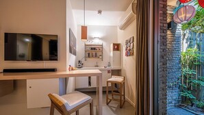 A modern kitchen with a flat-screen TV, wooden bar stools, and a built-in bench. - Antwerp For Two B&B for value seekers (Antwerpen)
