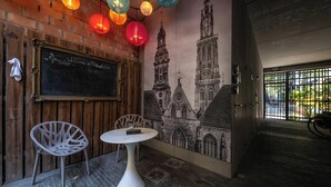 A cozy café with a mural of a historic building, wooden walls, and colorful hanging lanterns. - Antwerp For Two B&B for value seekers (Antwerpen)