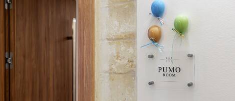 Un letrero en la pared con globos y el texto 'PUMO ROOM'.