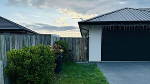 A residential property with a well-maintained lawn, a wooden fence, and a garage. - Your separate space in Wigram. (Christchurch)