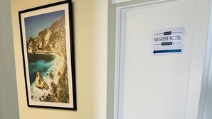 A hallway with a framed picture of a coastal landscape on the wall and a door with a 'No Guest Access' sign. - Your separate space in Wigram. (Christchurch)