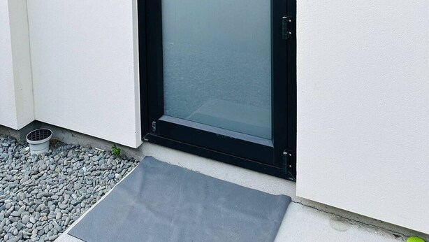 A modern black-framed glass door with a metal handle, set against a white wall. - Your separate space in Wigram. (Christchurch)