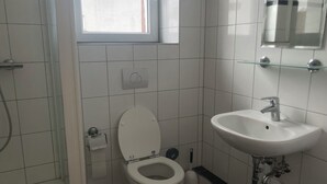 Un baño con inodoro, lavamanos y ducha.