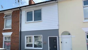 En rad av sammanbyggda hus med tydligt åtskilda ytterdörrar, numrerade 20 och 18.