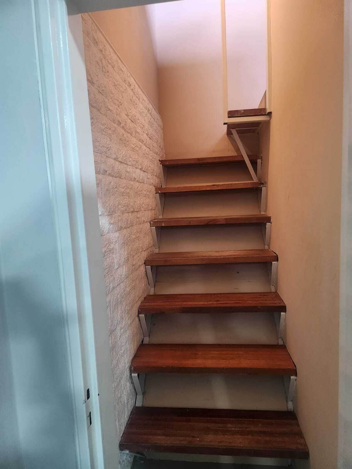A staircase with wooden steps and a brick wall.