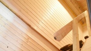 Eine Holztreppe mit Geländer und einer Leuchte darüber.