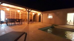 A covered outdoor area with a pool, wooden tables and chairs, and a small window. - Villa Porto Vecchio, near beach, 8/10 pers (sainte lucie de Porto vecchio)