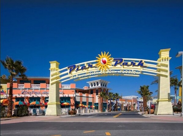 A sign for the Panama City Beach, Florida, with a sun emblem and the name 'Pine Park'. - Pier Park Paradise! Gulf Retreat, Private Pool, Sleeps 24 (Panama City Beach)