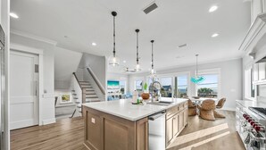 A modern kitchen with a large island, wooden cabinets, and pendant lighting. - Pier Park Paradise! Gulf Retreat, Private Pool, Sleeps 24 (Panama City Beach)