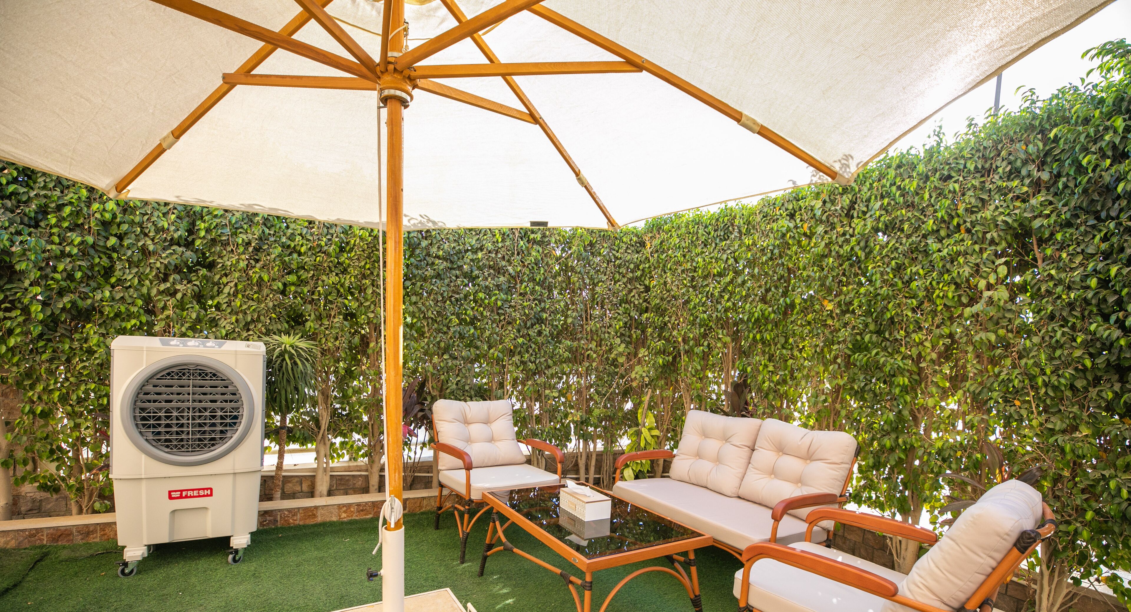 An outdoor seating area with a canopy, a table, and chairs.