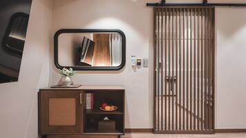 Un interior moderno con un armario de madera, un espejo y una puerta corredera.