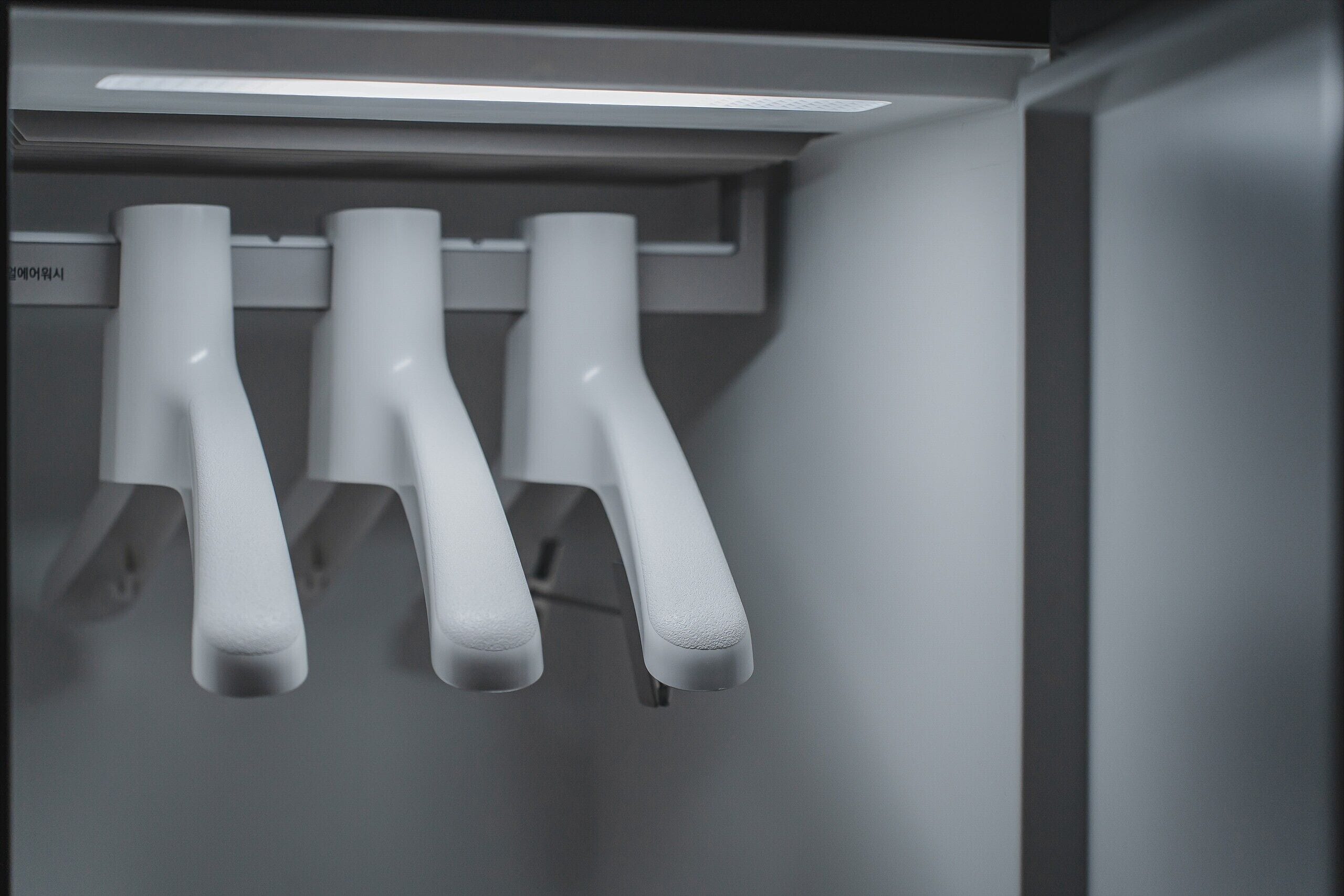 A close-up of three white, textured handles likely for a door or drawer.