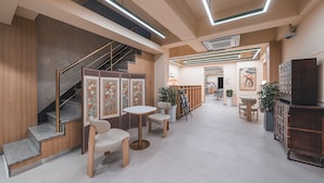 Un interior moderno con una escalera, una zona de estar y una recepción.