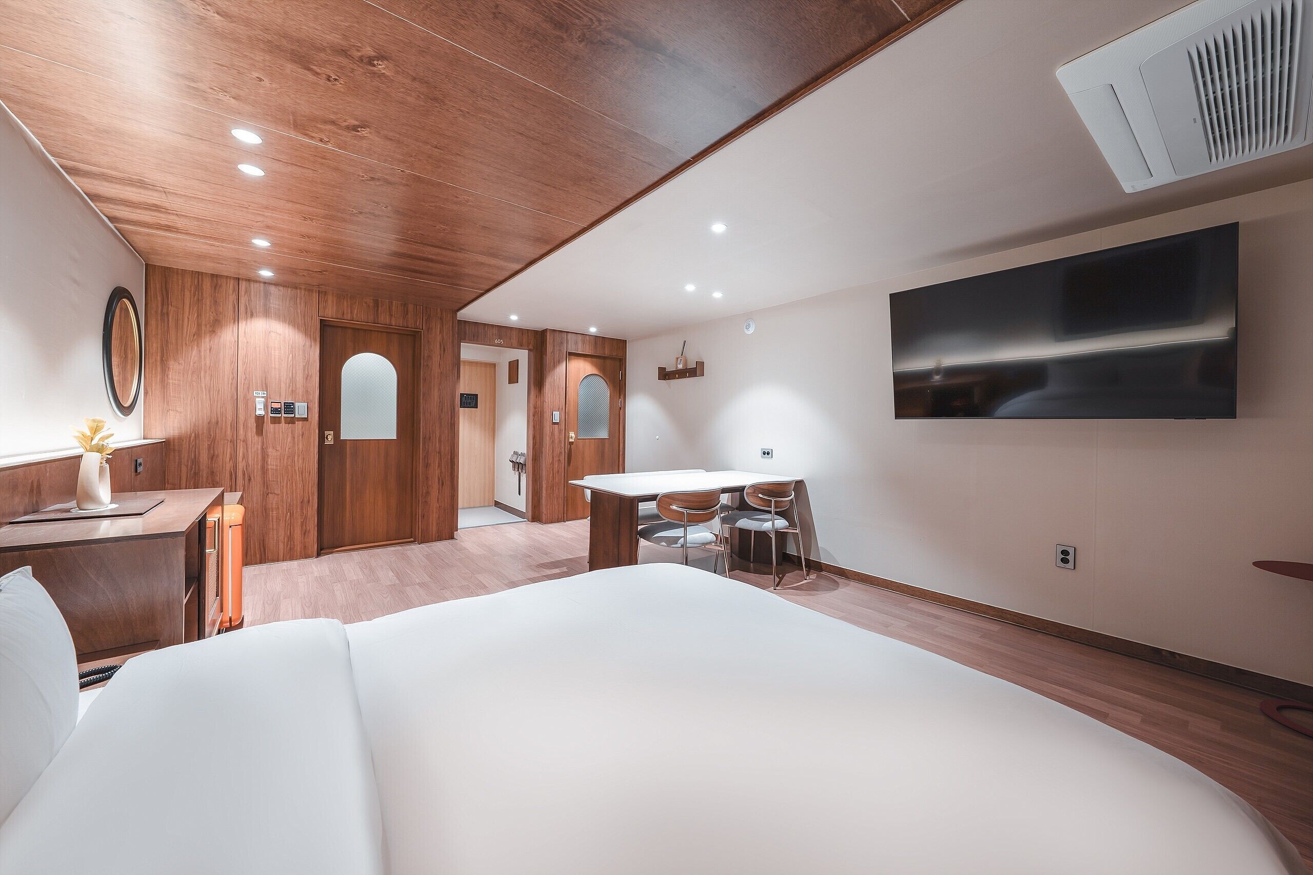 Una habitación de hotel moderna con una cama grande, un escritorio y una mesa de comedor.