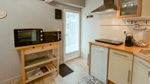 Una cucina compatta con forno a microonde, lavastoviglie e macchina del caffè sul piano di lavoro.