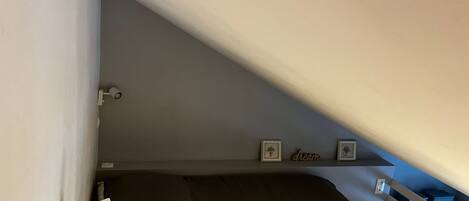 Habitación pequeña con literas, un escritorio y ventana con vista al exterior.