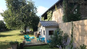 Un'area patio con tavolo e sedie, una piccola piscina e un prato verde.