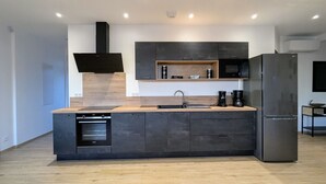 Une cuisine moderne dotée d’un îlot central, d’appareils électroménagers intégrés et d’un design épuré.