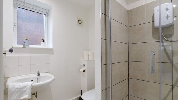 Un baño con lavamanos, inodoro y ducha.
