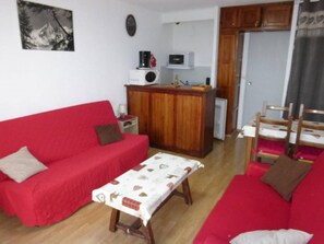 Cozy living space with a sofa, bench, and kitchenette, featuring a microwave and coffee maker.