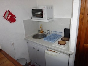Efficient kitchenette with microwave oven, sink, and refrigerator.