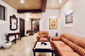 Relax in a classic living room with a comfortable sofa set, armchair, and wooden coffee table.