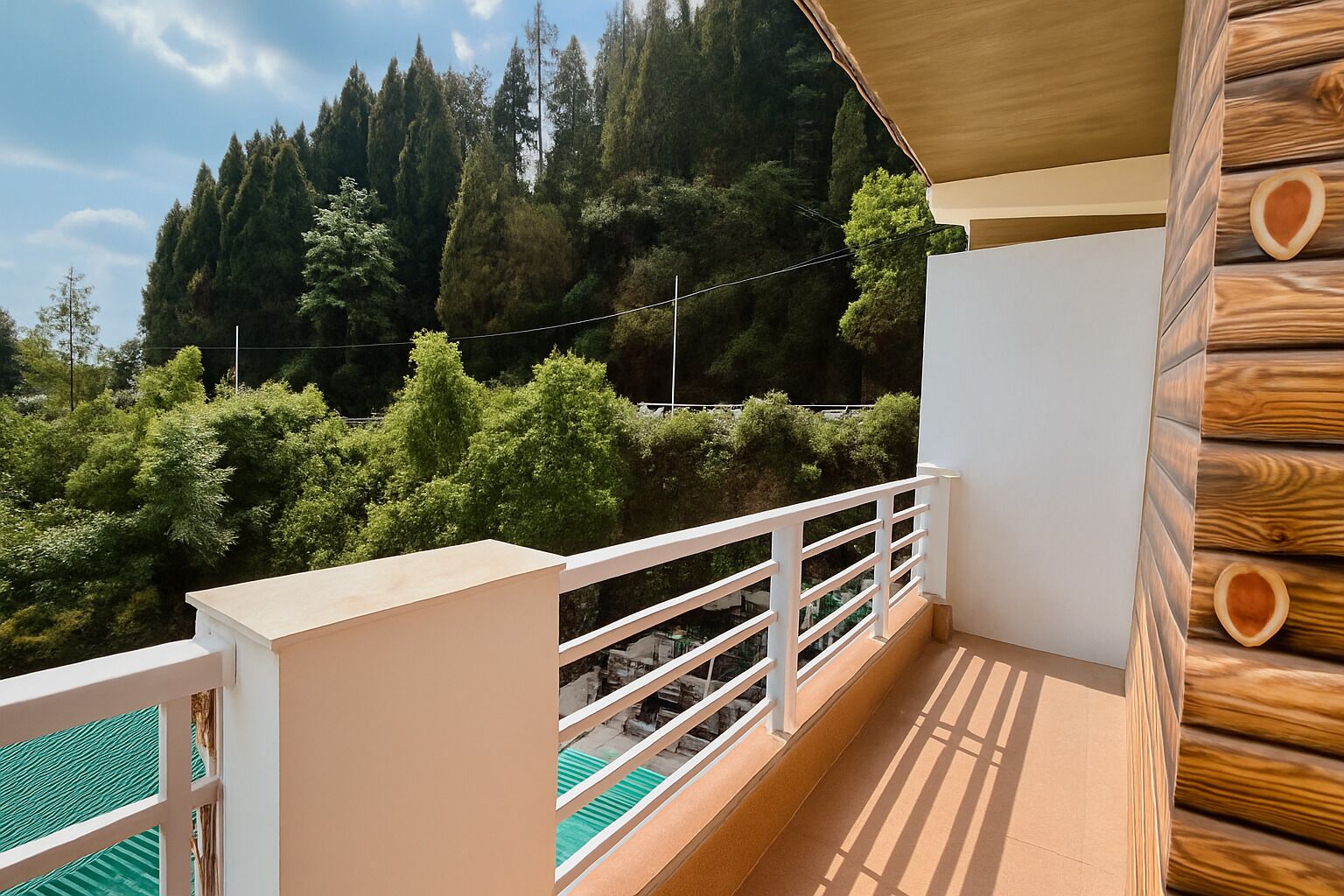 Een balkon met houten leuning, uitzicht op een bebost gebied en een heldere lucht.