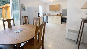A kitchen with a dining table, chairs, a refrigerator, microwave, stove, and cabinets. - 3-bedroom house near the beach with private garden and parking (Longeville-sur-Mer)