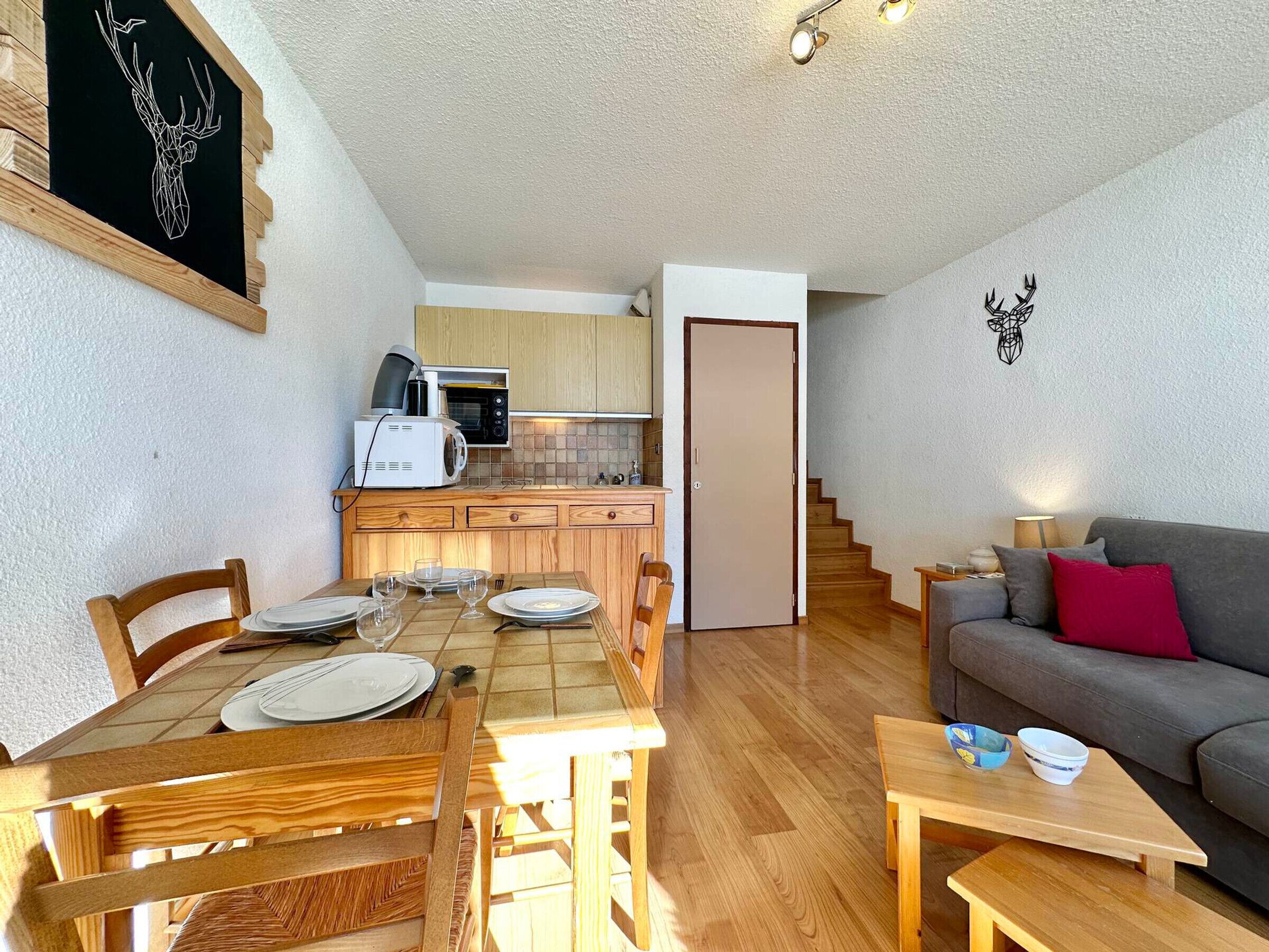 Un espai habitable reduït amb zona de menjador, petita cuina i sofà.