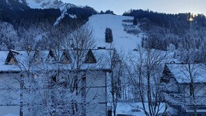 Un paysage montagneux enneigé, avec des bâtiments au premier plan.